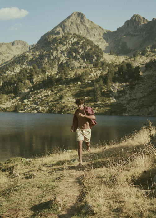 Una persona corre lungo un sentiero vicino a un lago alpino